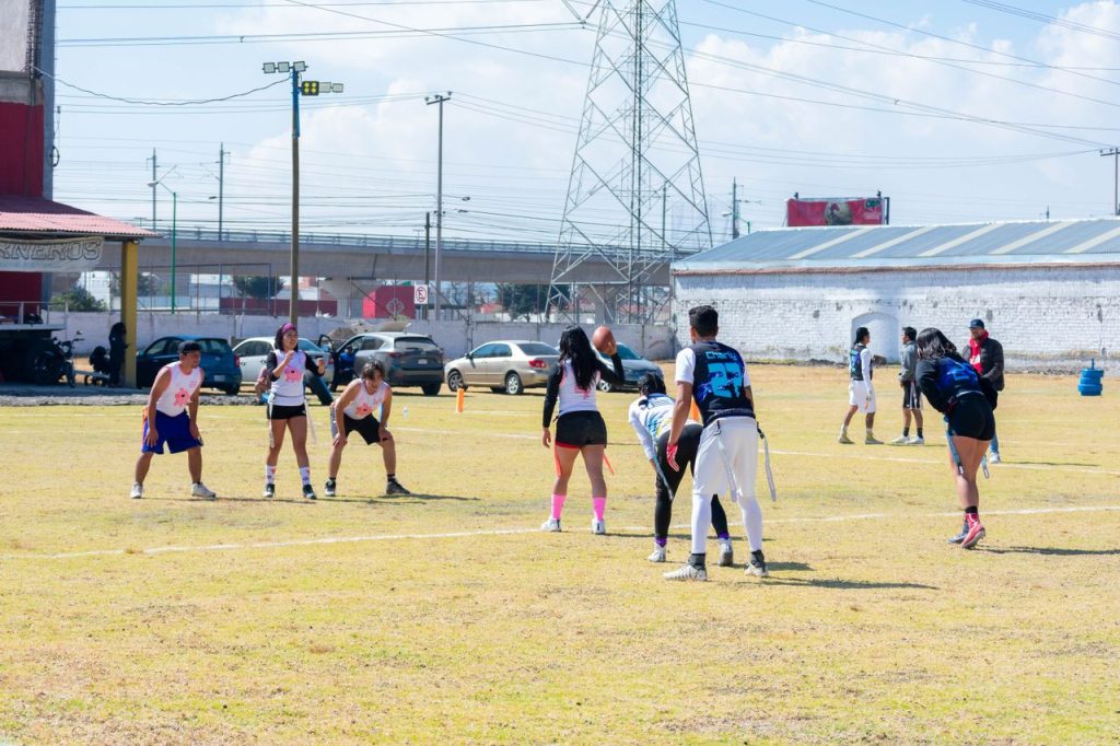 A youth flag football game in Toluca, featuring mixed teams in action outdoors.