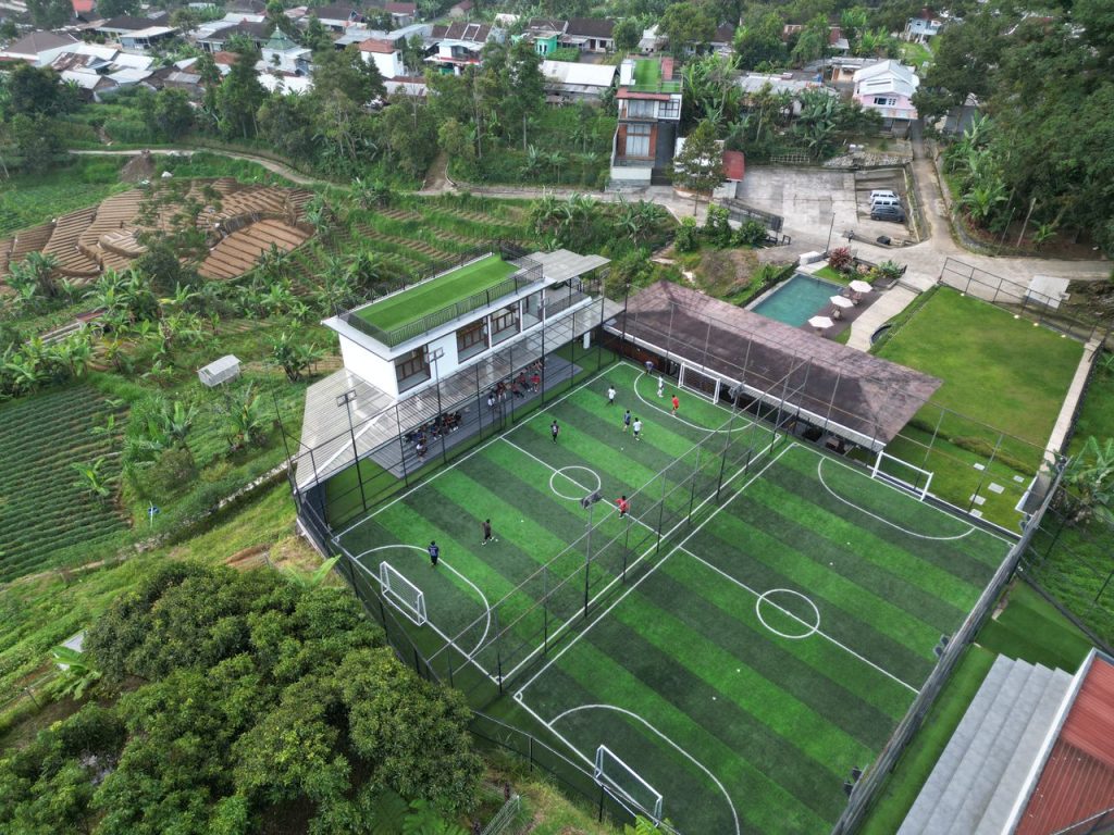 Aerial view of a vibrant soccer field in Central Java, Indonesia, surrounded by lush greenery.